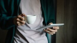 Tablet mit Nachrichtenseite neben einer Tasse Kaffee